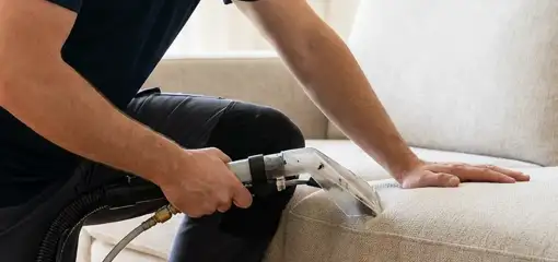 Professional upholstery cleaner deep-cleaning a fabric sofa with a handheld extraction tool, Anaheim, CA.